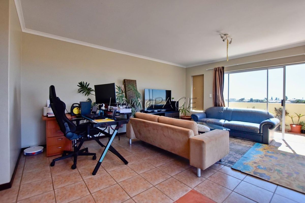 Spacious living area featuring tiled flooring and large sliding glass doors that provide access to an outdoor balcony area.