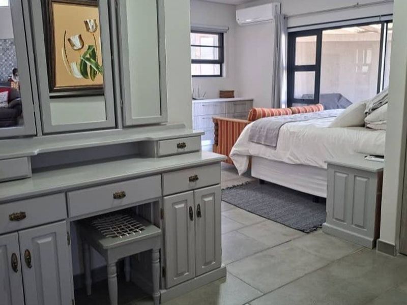 Spacious bedroom featuring tiled flooring, built-in cabinetry, and a sliding glass door providing access to the exterior.