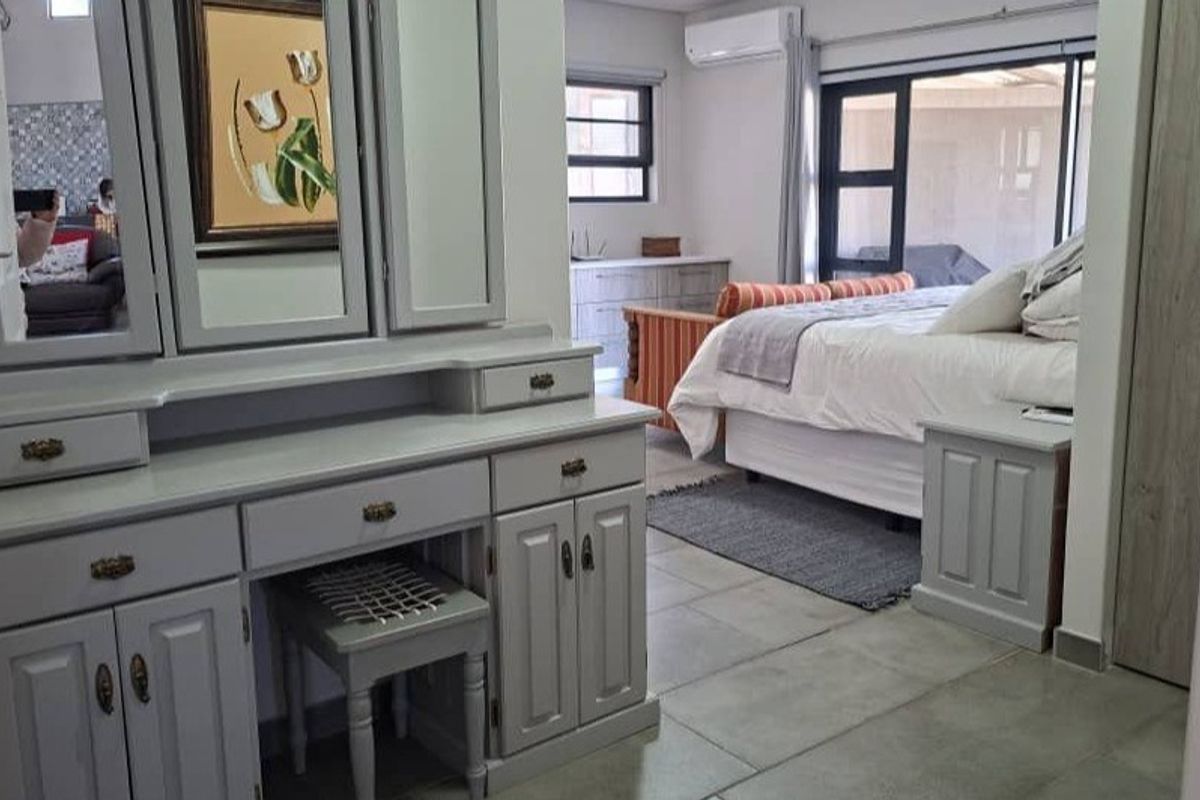 Spacious bedroom featuring tiled flooring, built-in cabinetry, and a sliding glass door providing access to the exterior.