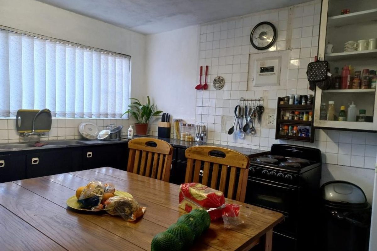 A functional kitchen featuring dark cabinetry, a tiled splashback, and a freestanding stove, offering potential for modernization and aesthetic updates.