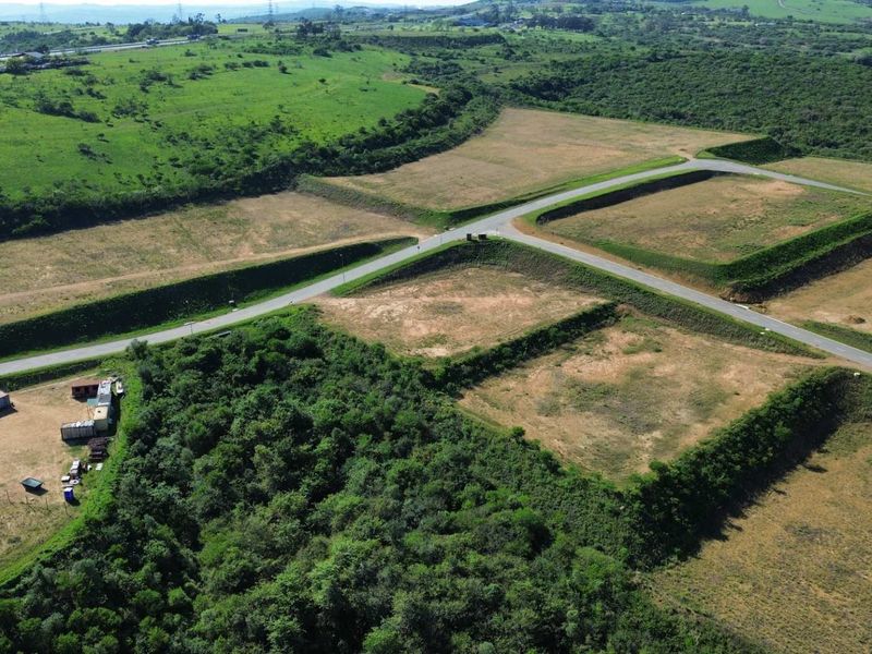 Aerial view of a developed industrial site featuring cleared plots, paved access roads, and established earth berms in a rural setting.