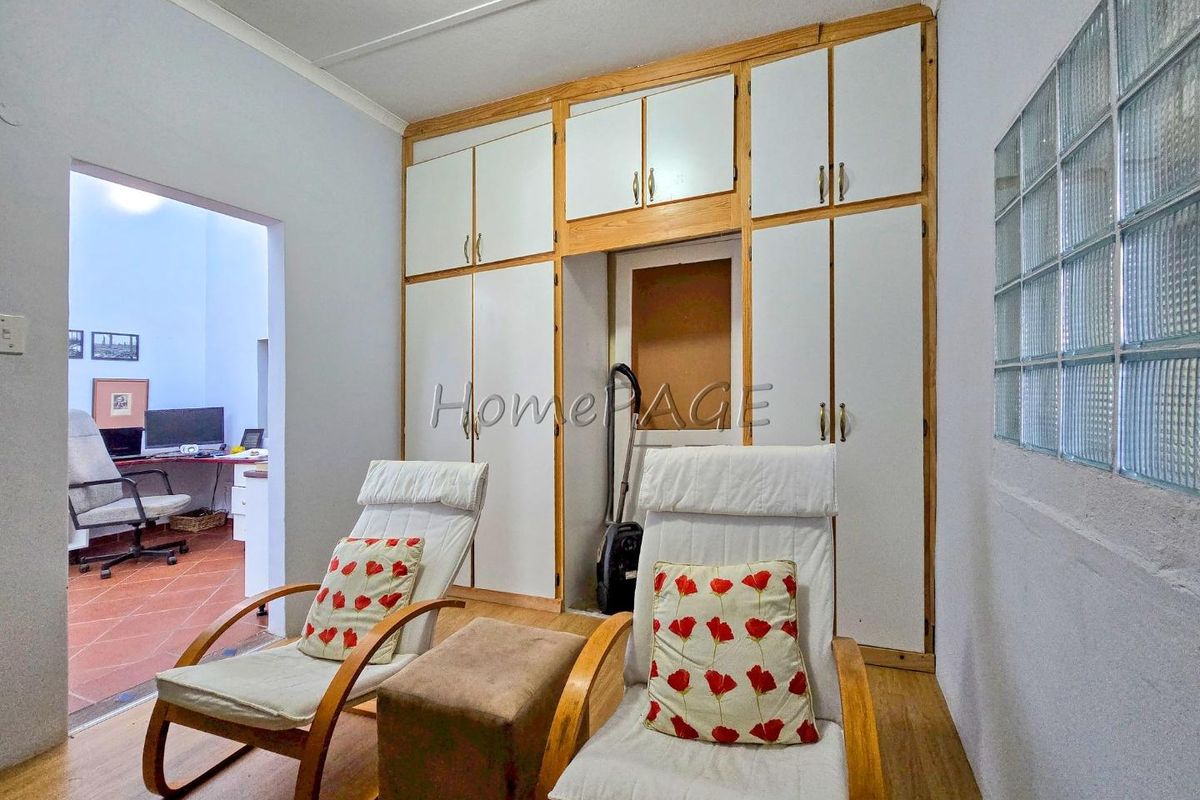 A bedroom featuring extensive built-in floor-to-ceiling cabinetry and a glass block feature wall, providing ample storage and natural light.