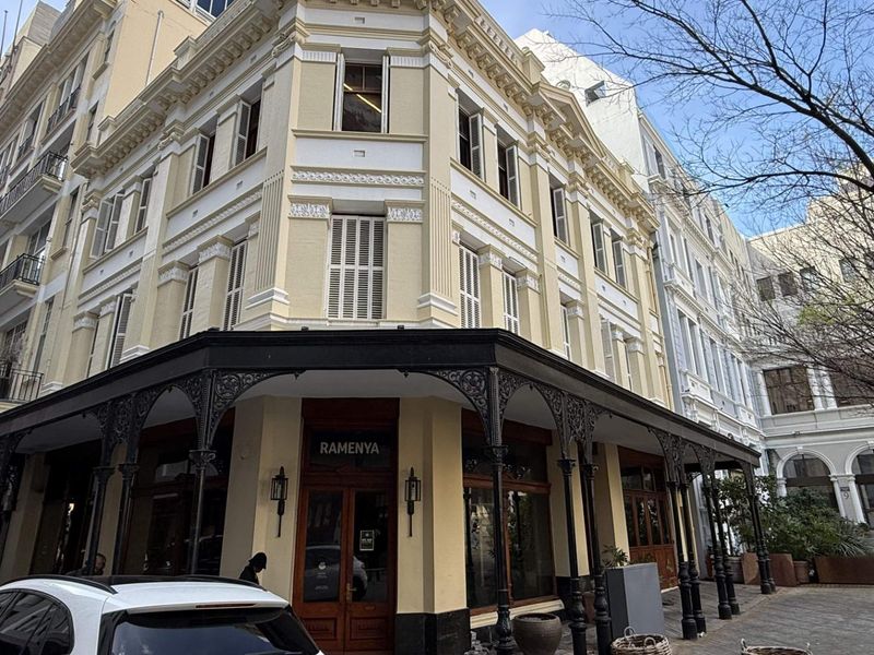 A well-maintained multi-story retail building featuring a classic facade with ornate cast iron veranda detailing and timber-framed shopfront entrance.
