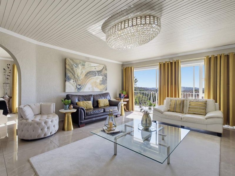 Spacious living room featuring tiled floors, a decorative tongue and groove ceiling, a crystal chandelier, and sliding doors leading to a balcony with views.
