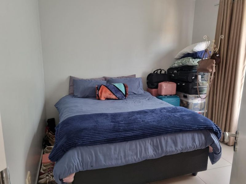 A functional bedroom featuring neutral wall finishes and tiled flooring, suitable for a comfortable sleeping space.