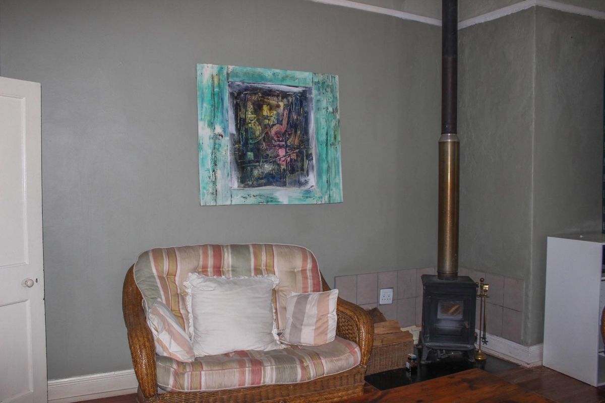 A living room area featuring a built-in wood-burning stove with a tiled hearth and chimney flue, set against a painted wall.