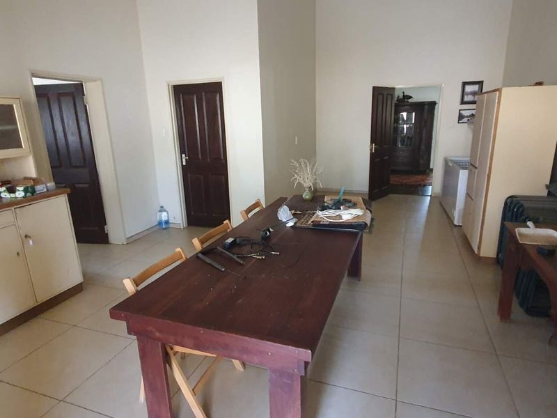 Open plan living and dining area featuring tiled flooring, built-in cabinetry, and multiple access points to adjacent rooms.