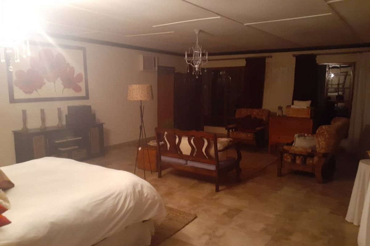 Spacious bedroom featuring tiled flooring, a drop ceiling with panel detailing, and integrated lighting fixtures.