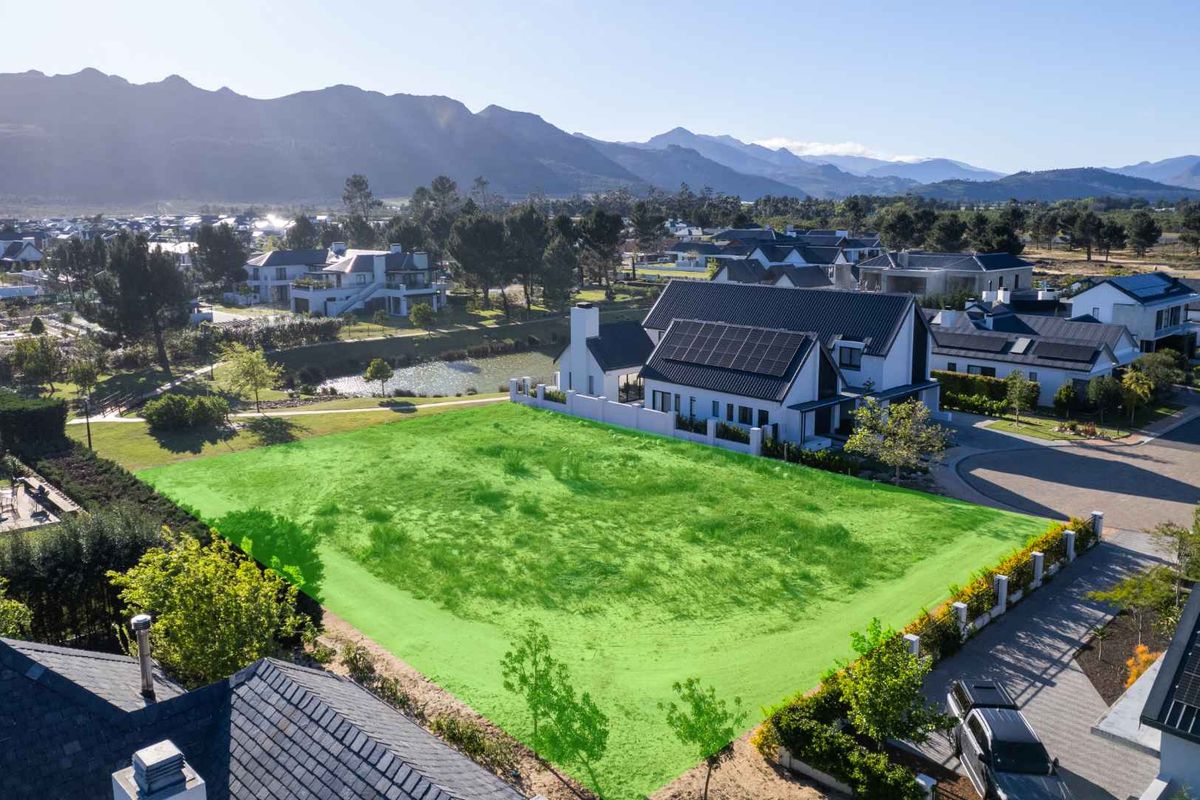 Aerial view of a vacant residential land plot in a developed estate, highlighting the available building space and surrounding neighborhood context.
