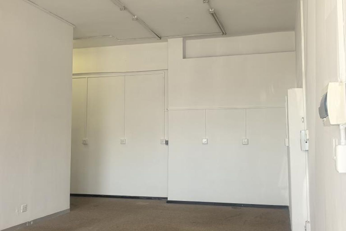 An empty, open-plan commercial office space featuring neutral walls, carpeted flooring, and integrated strip lighting, suitable for various business configurations.