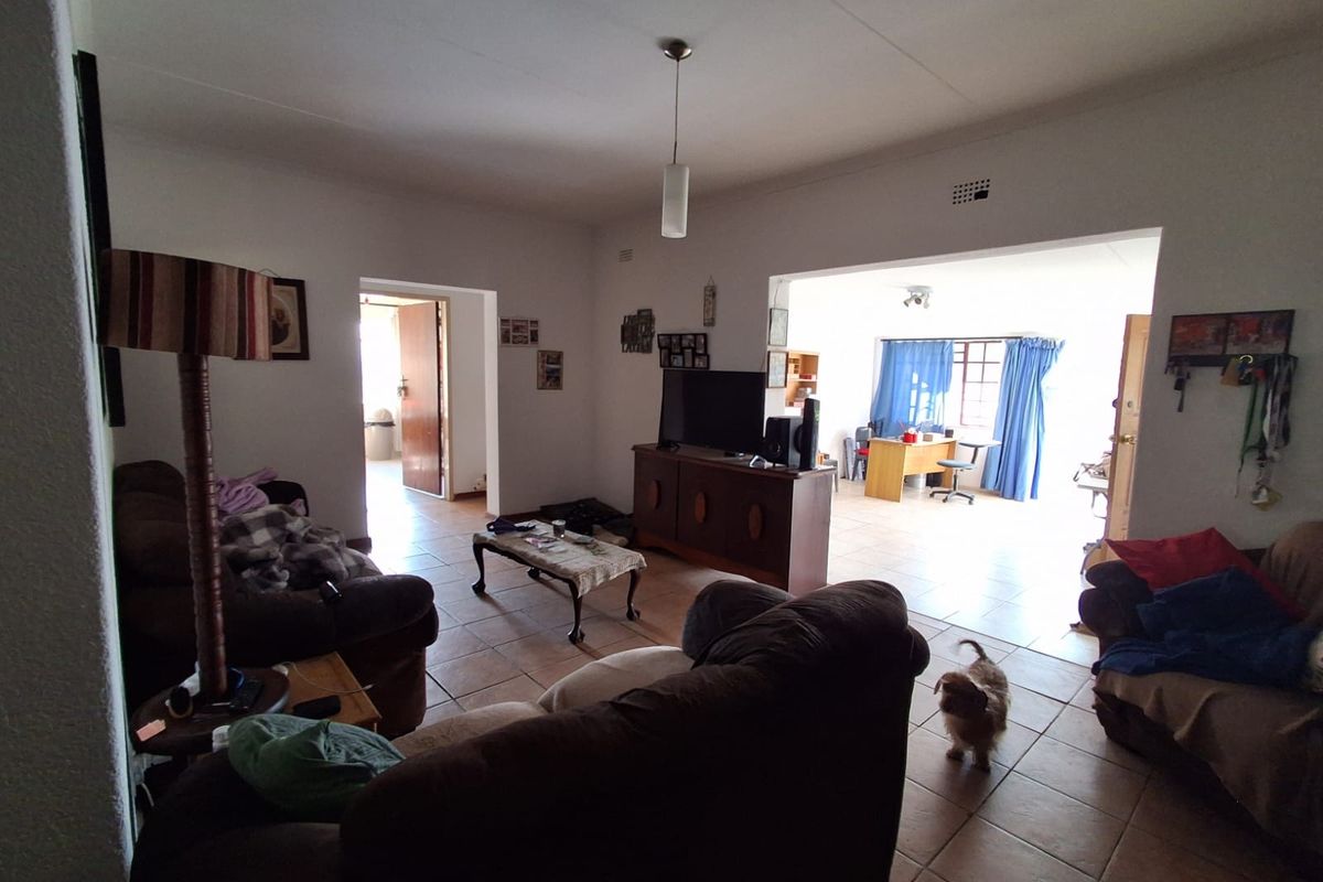 Spacious living area featuring tiled flooring and an open-plan layout connecting to an adjacent room.