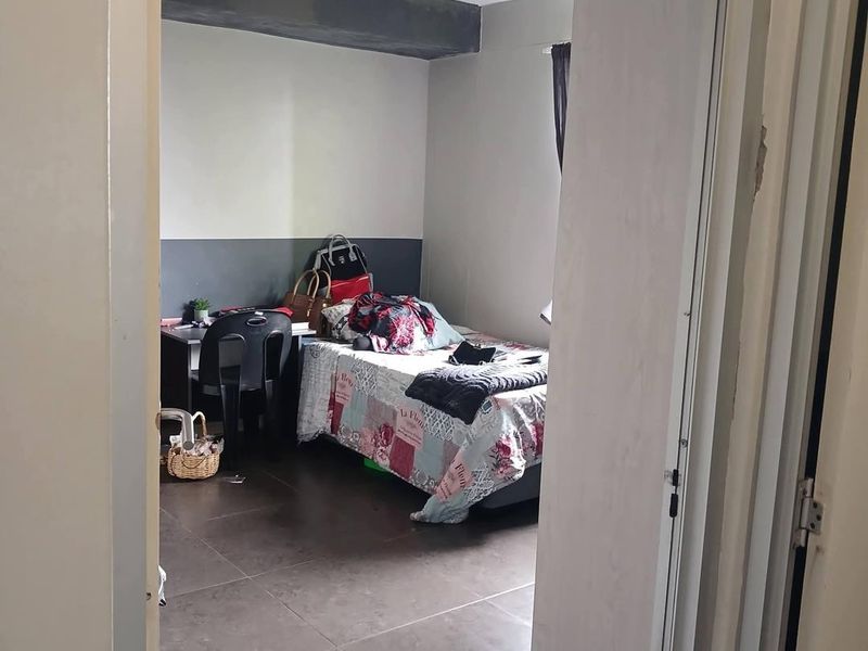 A bedroom featuring dark tiled flooring and two-tone painted walls, viewed from the doorway.