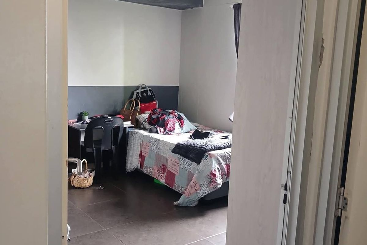 A bedroom featuring dark tiled flooring and two-tone painted walls, viewed from the doorway.