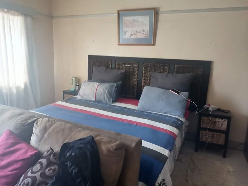 A standard bedroom featuring neutral wall tones and a traditional picture rail, providing a functional space for rest.