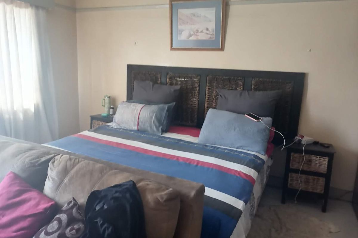 A standard bedroom featuring neutral wall tones and a traditional picture rail, providing a functional space for rest.