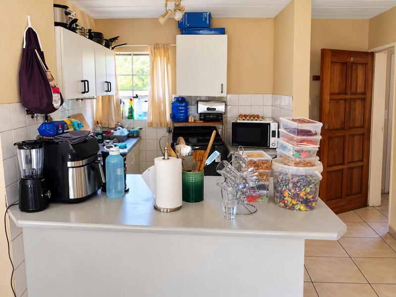 A functional kitchen featuring built-in cabinetry, tiled backsplash, and a breakfast bar, providing a practical layout for daily meal preparation.