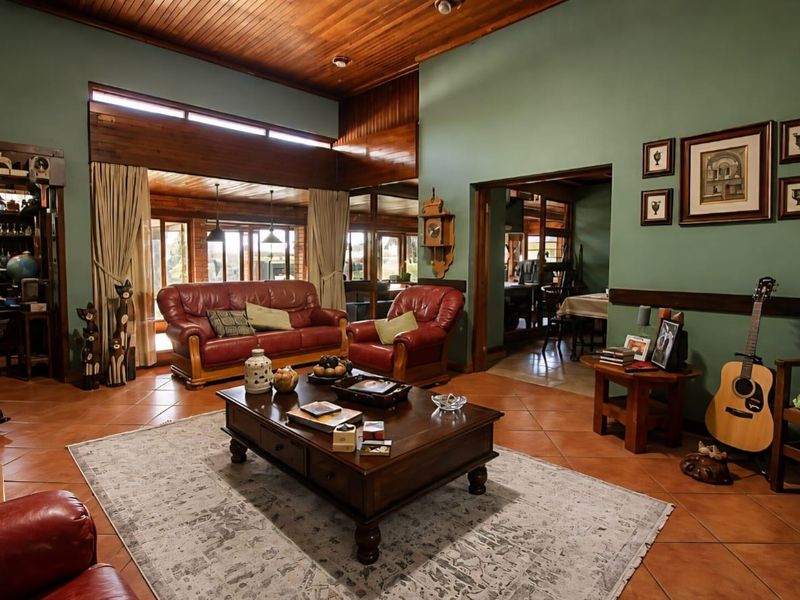 Spacious living room featuring a high timber-clad vaulted ceiling, terracotta floor tiles, and large clerestory windows that provide ample natural light.