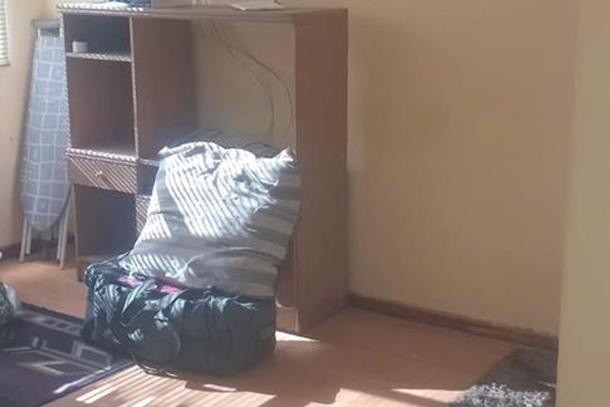 A living area featuring laminate flooring and coving, currently requiring maintenance to address exposed wiring and floor edge wear.