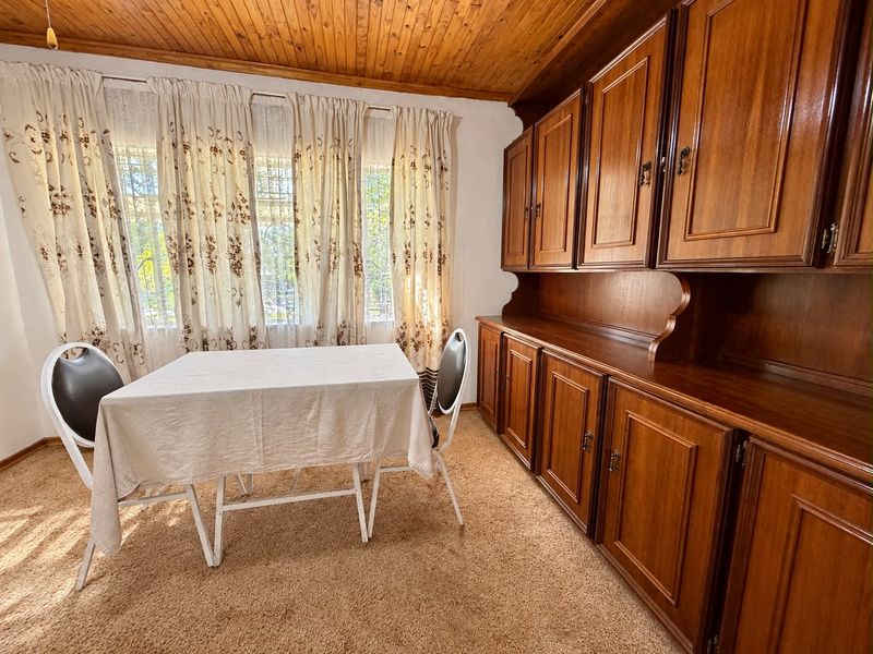 Dining room featuring built-in wooden cabinetry, a timber ceiling, and carpeted flooring, offering a traditional aesthetic with potential for modern updates.