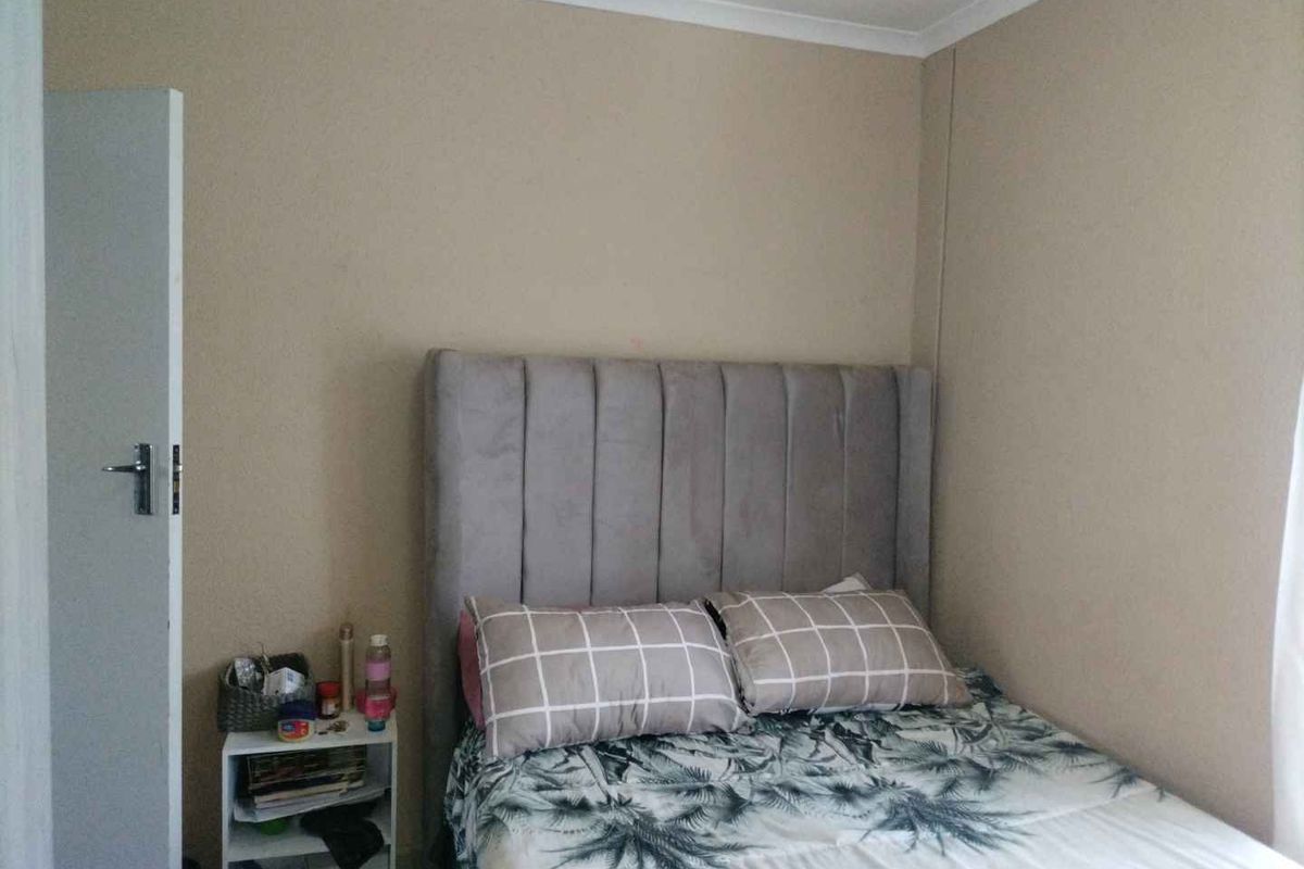 A standard bedroom featuring neutral wall tones and a built-in door, providing a functional and simple living space.