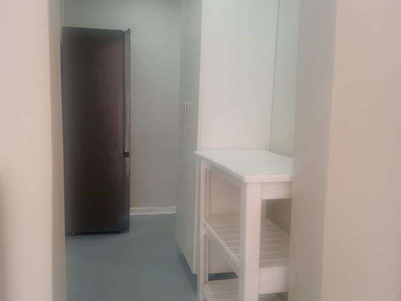 A functional scullery or utility area featuring built-in cabinetry and neutral flooring, providing additional storage and prep space.