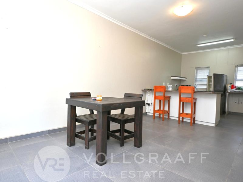 Open plan living and kitchen area featuring tiled flooring and a breakfast bar counter.