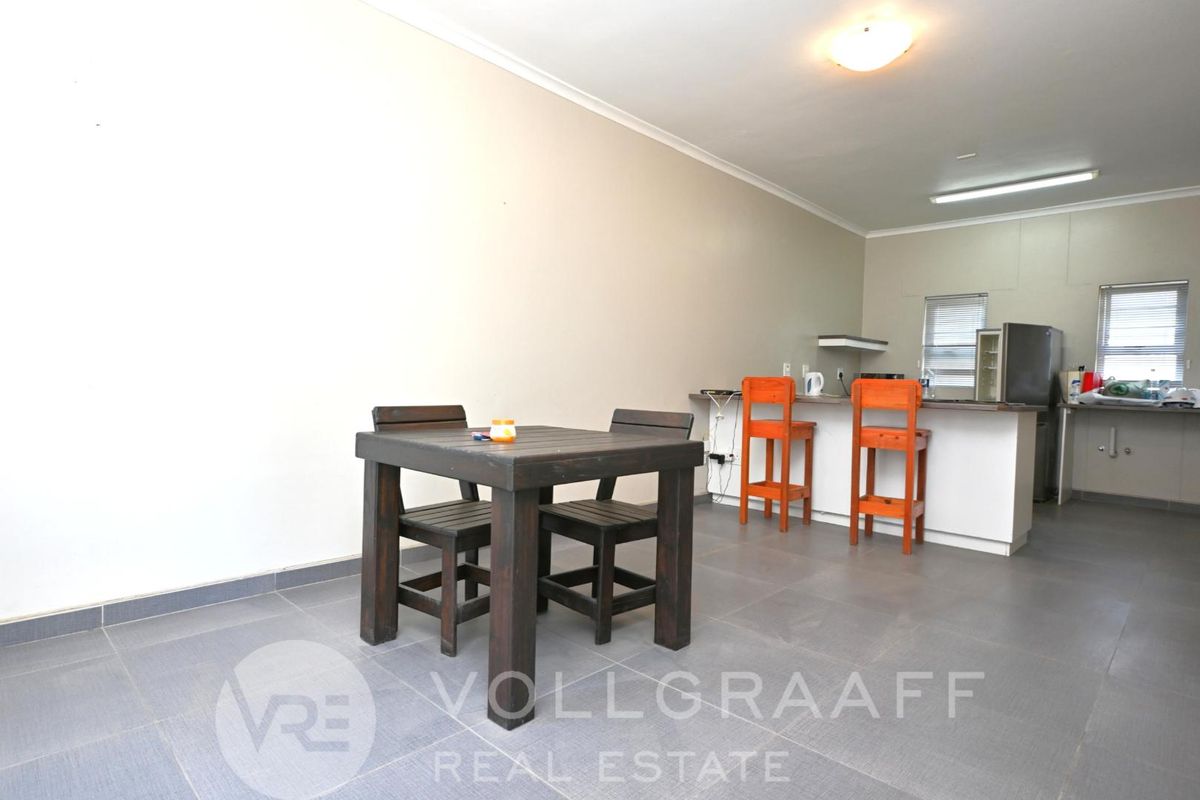Open plan living and kitchen area featuring tiled flooring and a breakfast bar counter.