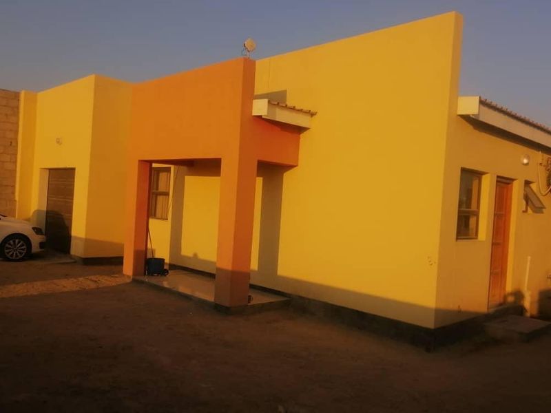 Front elevation of a modern single-story house featuring a covered entrance porch and painted exterior walls.
