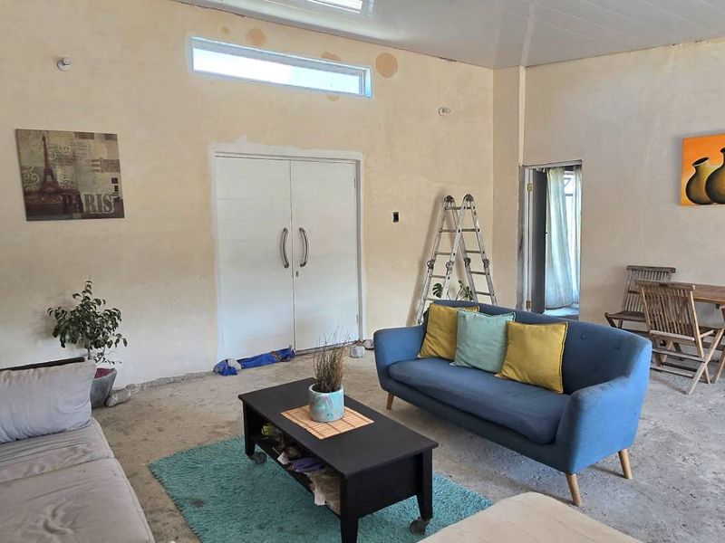 Spacious living area featuring unfinished walls, concrete flooring, and a clerestory window, offering a blank canvas for renovation and interior design updates.