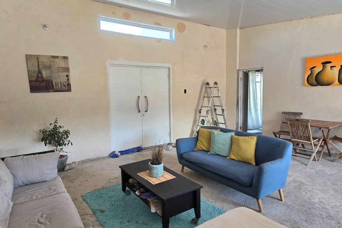 Spacious living area featuring unfinished walls, concrete flooring, and a clerestory window, offering a blank canvas for renovation and interior design updates.