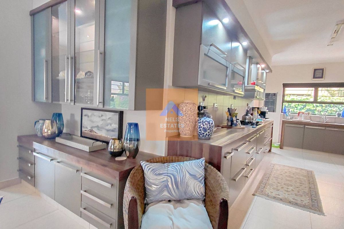 Modern kitchen featuring extensive built-in cabinetry, stone countertops, integrated cooking appliances, and recessed lighting, offering a functional and contemporary workspace.