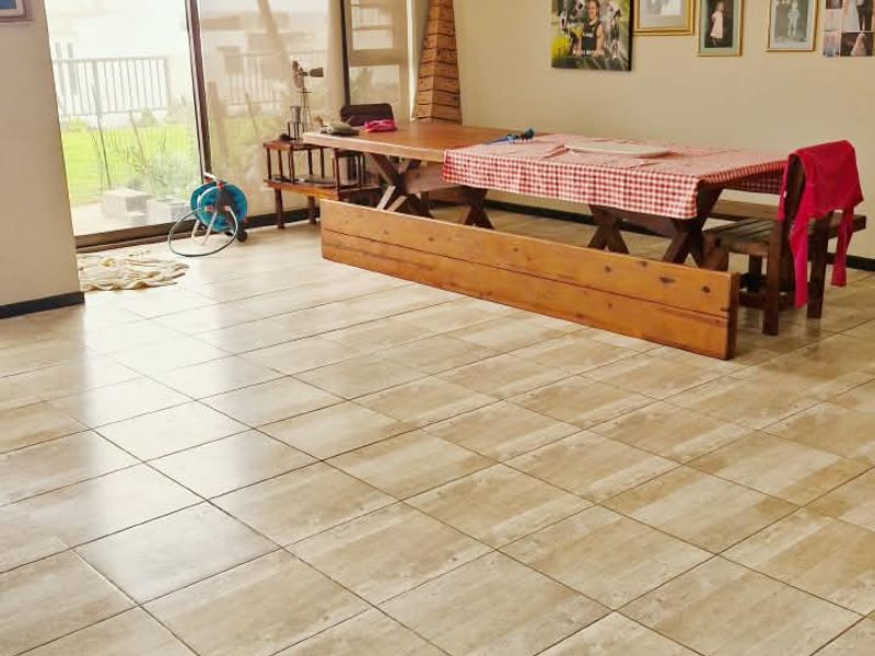 Spacious living area featuring neutral tiled flooring and large sliding glass doors providing natural light and access to the outdoor space.