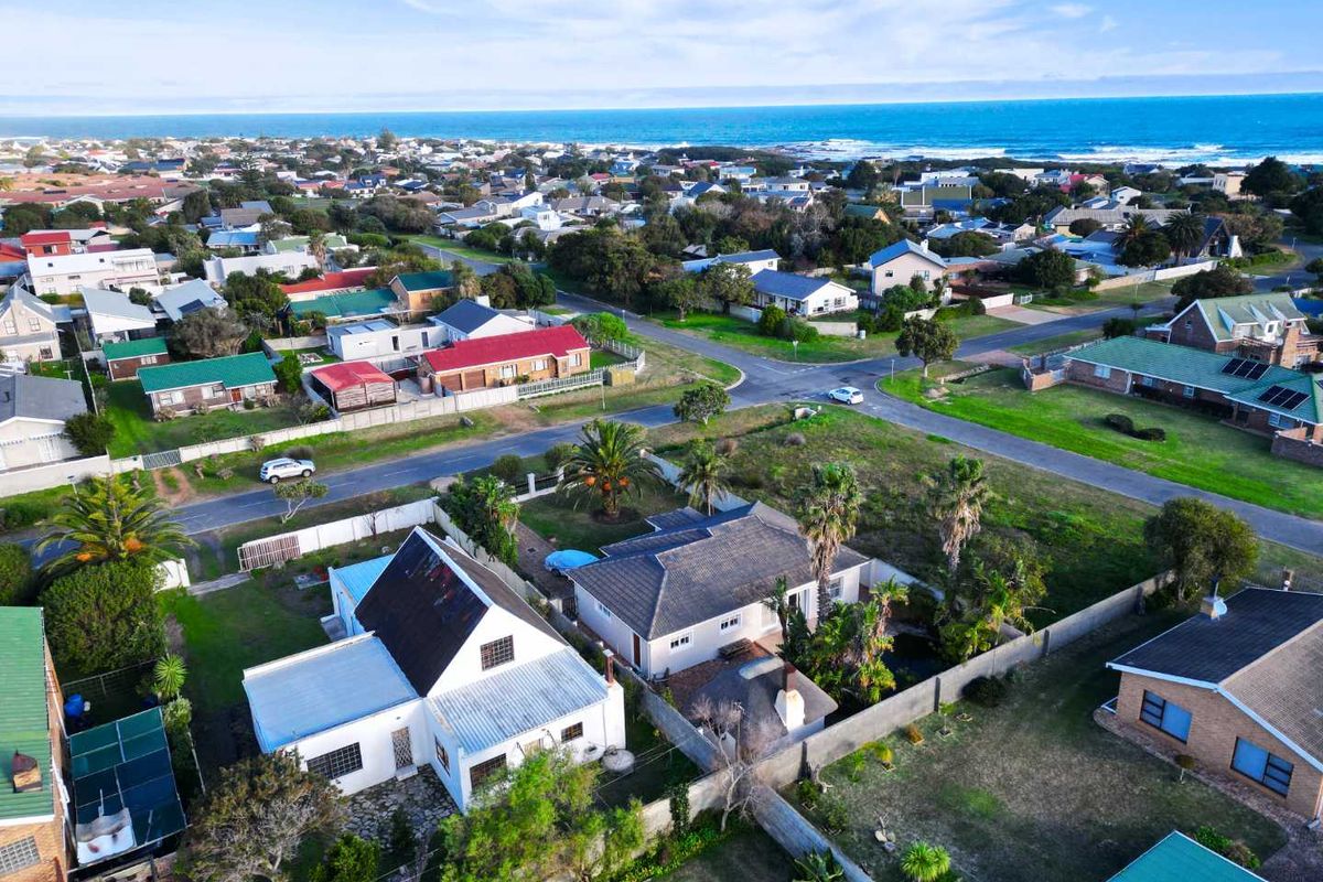 Aerial view of the residential property showing the roof structure, garden, and surrounding coastal neighborhood context.