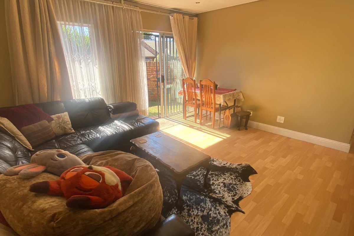 A living room featuring laminate flooring and sliding glass doors that provide access to the outdoor area.