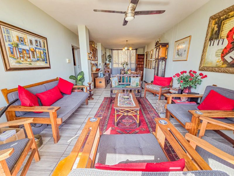 Spacious open-plan living and dining area featuring tiled flooring, a ceiling fan, and neutral wall finishes, offering a versatile layout for comfortable living.