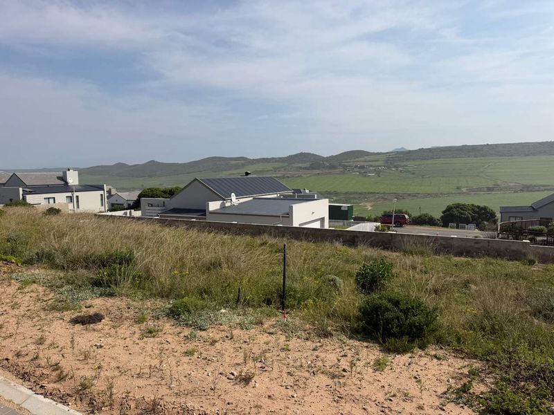 A view of the vacant residential land looking out over the surrounding neighbourhood and rolling green hills in the distance.