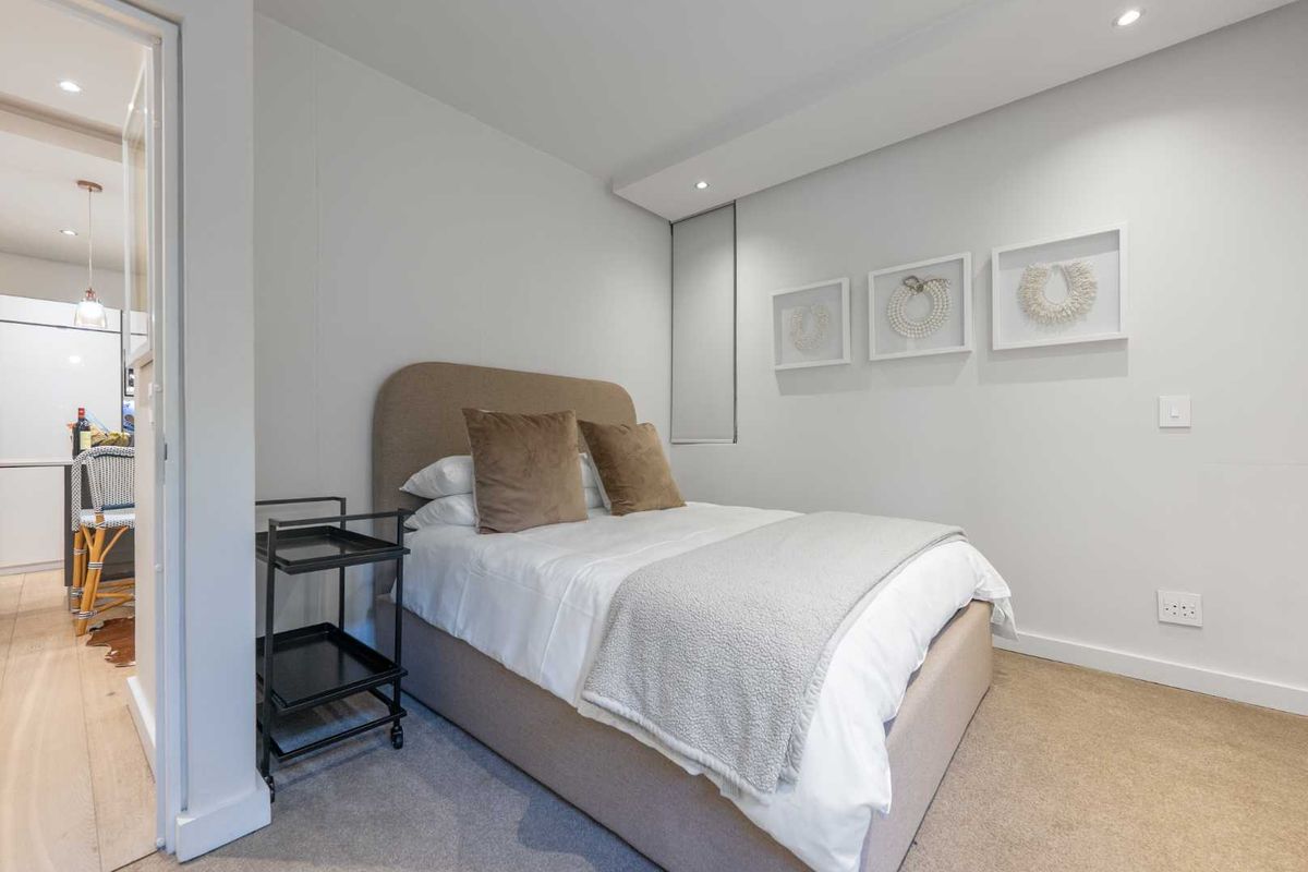 A well-maintained bedroom featuring neutral carpeting, recessed ceiling lighting, and clean wall finishes, offering a comfortable and modern living space.