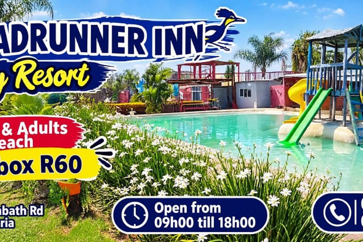 Outdoor swimming pool area featuring a children's play structure with a slide, set within a landscaped resort environment.