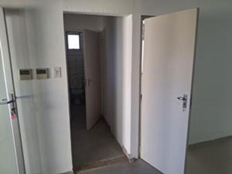 A functional hallway area connecting multiple rooms, featuring neutral finishes and standard internal door access.