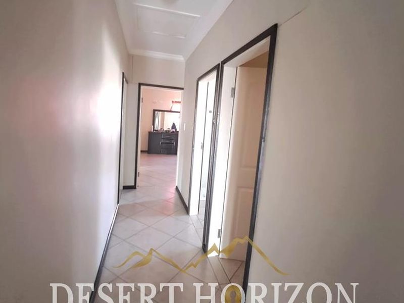 A functional hallway featuring tiled flooring and multiple internal door access points, connecting various areas of the home.