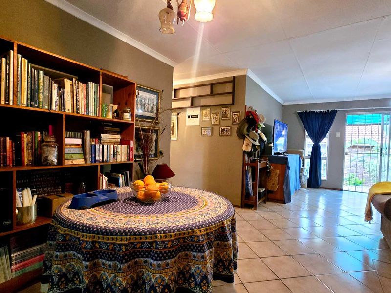 Open plan living and dining area featuring ceramic floor tiles, built-in shelving, and a sliding glass door providing access to the exterior.
