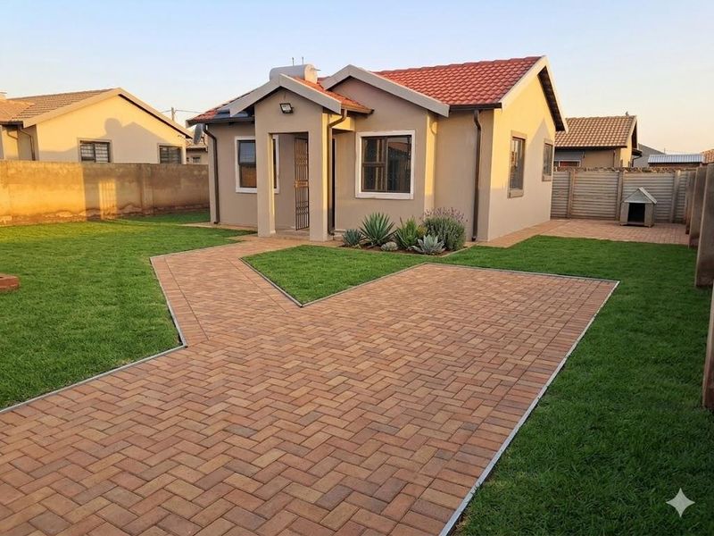 A well-maintained single-story house featuring a tiled roof, paved driveway, and neat garden with established landscaping and boundary walls.