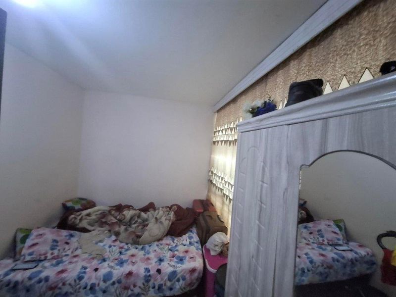 A bedroom featuring crown molding and a window, providing a functional space for rest.