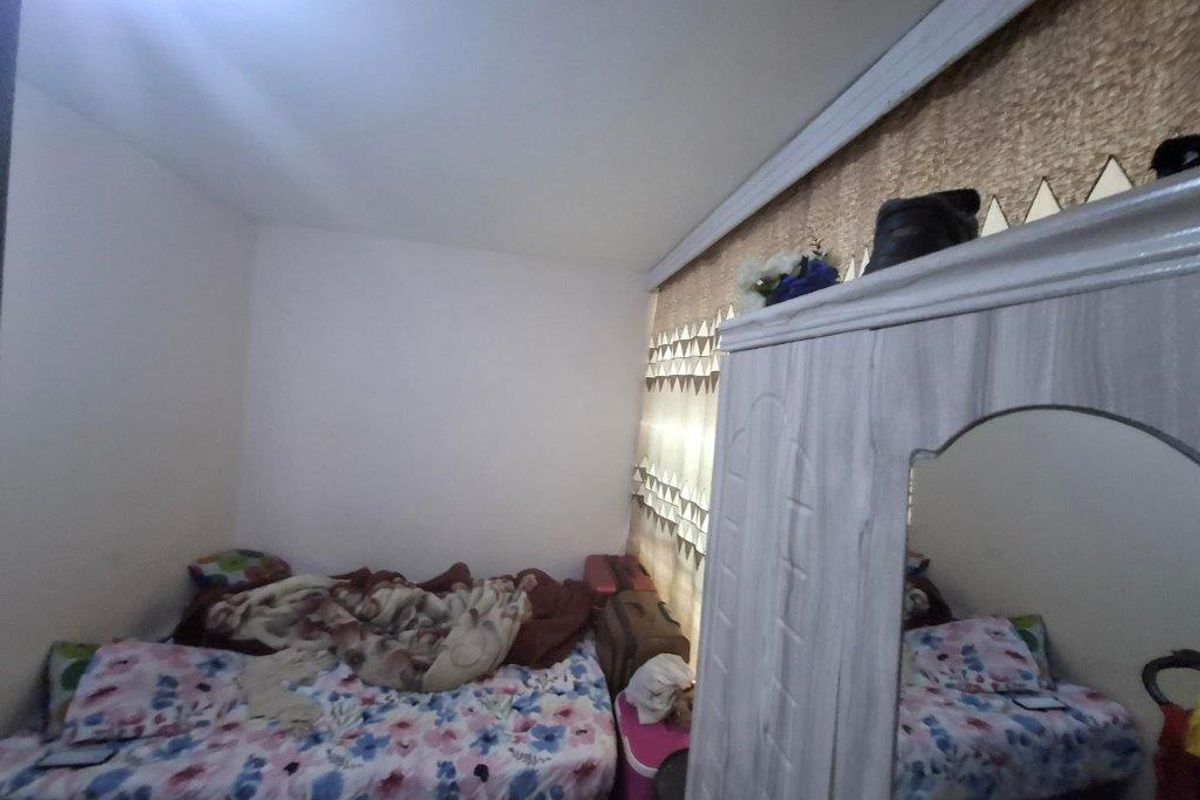 A bedroom featuring crown molding and a window, providing a functional space for rest.