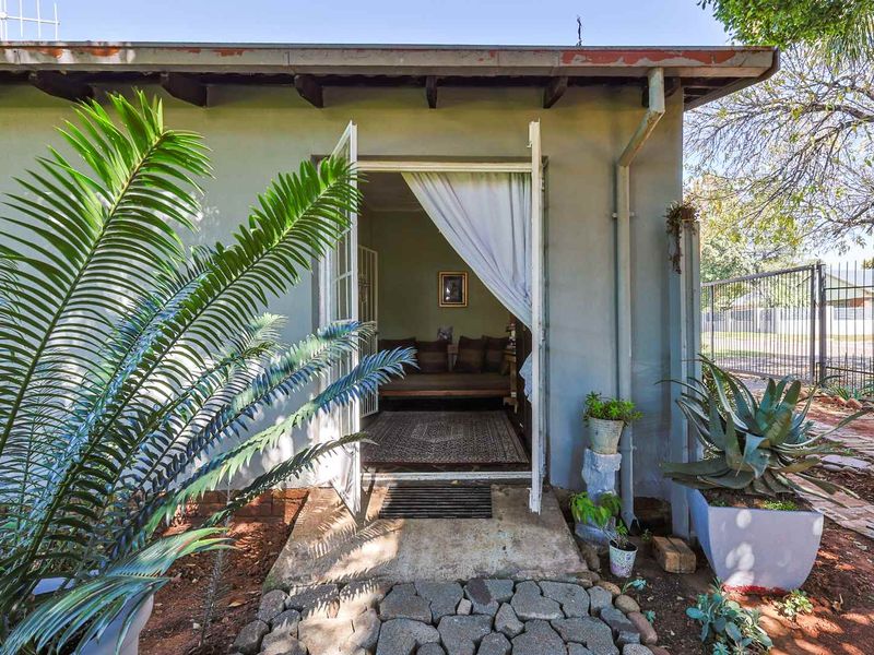 View of the rear exterior entrance featuring a concrete threshold, double doors, and access to the garden area.