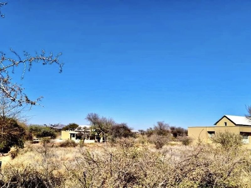 A view of the residential property and surrounding natural landscape, showcasing the building exterior and open land.