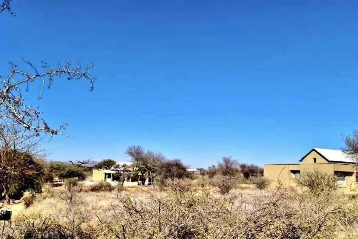 A view of the residential property and surrounding natural landscape, showcasing the building exterior and open land.