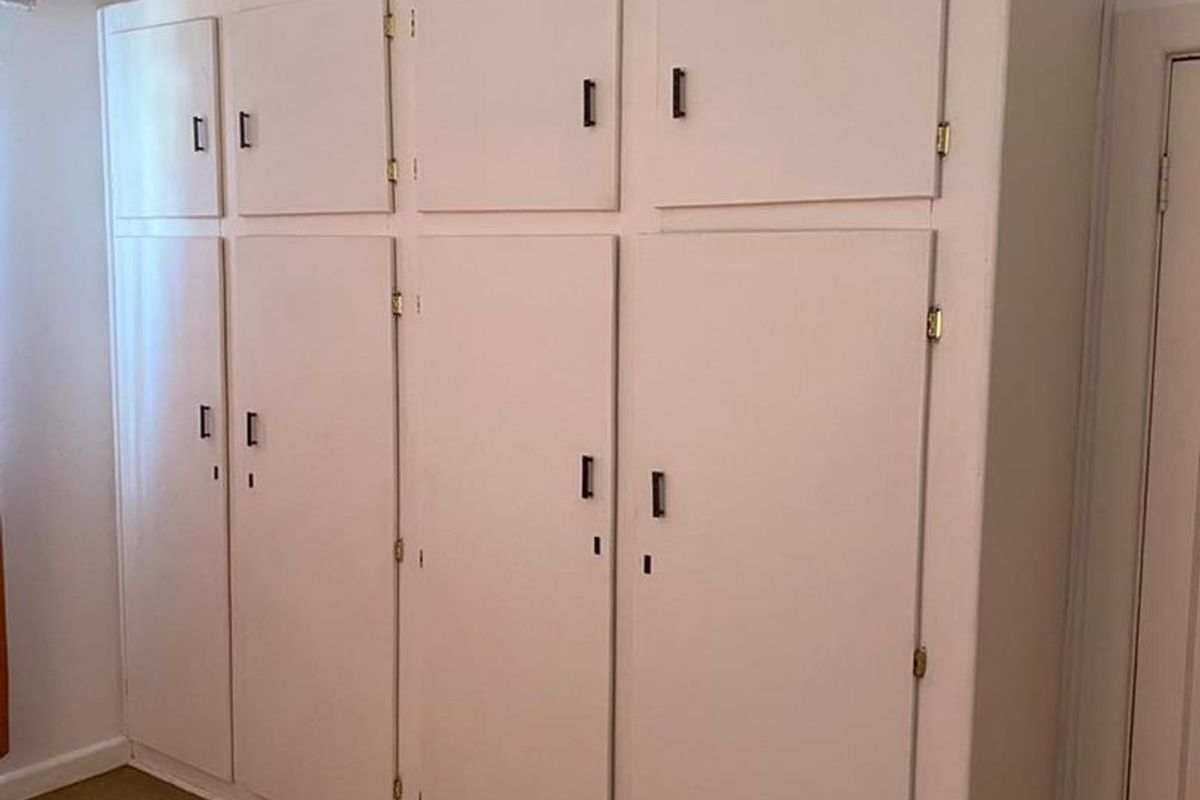 A bedroom featuring extensive built-in floor-to-ceiling storage cabinetry with multiple doors and overhead compartments.