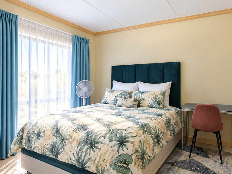 A well-lit bedroom featuring tiled flooring, large windows with curtains, and decorative ceiling cornicing, providing a comfortable and functional living space.