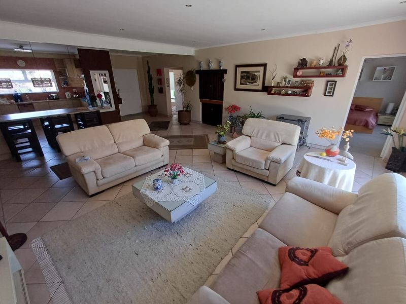Spacious open-plan living area featuring tiled flooring, recessed lighting, and a connected kitchen with island, offering a functional and versatile layout.